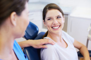 Woman smiling up at her dentist after learning about oral surgery options available at her Surrey BC dentist office.